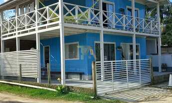 Imagem 3: Casa charmosa em estilo praiano, com fachada colorida e ampla varanda que integra os ambie