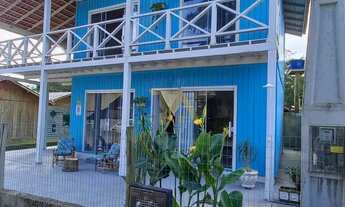 Imagem 4: Casa charmosa em estilo praiano, com fachada colorida e ampla varanda que integra os ambie