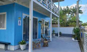 Imagem 5: Casa charmosa em estilo praiano, com fachada colorida e ampla varanda que integra os ambie