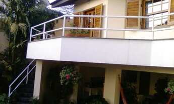 Imagem 2: Sobrado em rua de alto padrão com quintal e árvores frutíferas