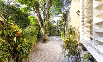 Imagem: Casa ensolarada com muito verde e piscina