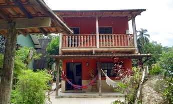 Imagem: Casa com cachoeira e mata atlântica