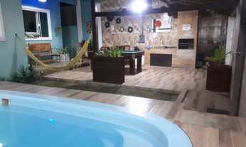 Imagem: Casa com piscina e churrasqueira entre a