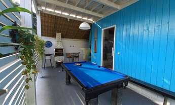 Imagem 7: Casa charmosa em estilo praiano, com fachada colorida e ampla varanda que integra os ambie