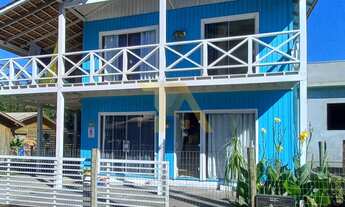 Imagem 1: Casa charmosa em estilo praiano, com fachada colorida e ampla varanda que integra os ambie