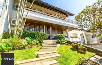 Imagem: A casa possui 4 Dormitórios, 5 Banheiros, 4 Vagas na garagem