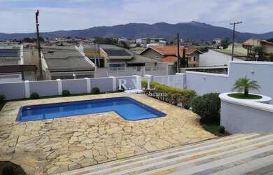 Imagem: A casa possui 4 Dormitórios, 5 Banheiros, 4 Vagas na garagem