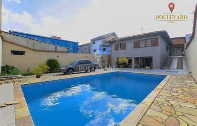 Imagem: A casa possui 4 Dormitórios, 4 Banheiros, 5 Vagas na garagem