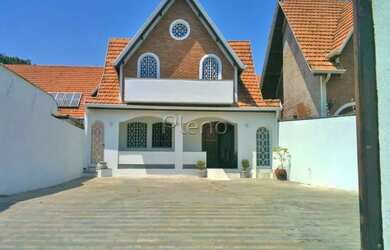 Imagem: A casa possui 3 Dormitórios, 4 Banheiros, 5 Vagas na garagem