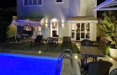 Imagem: A casa possui 4 Dormitórios, 5 Banheiros, 4 Vagas na garagem