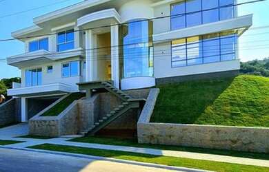 Imagem: A casa possui 4 Dormitórios, 5 Banheiros, 4 Vagas na garagem