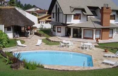 Imagem: A casa possui 4 Dormitórios, 4 Banheiros, 5 Vagas na garagem