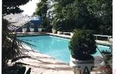 Imagem: A casa possui 4 Dormitórios, 4 Banheiros, 5 Vagas na garagem