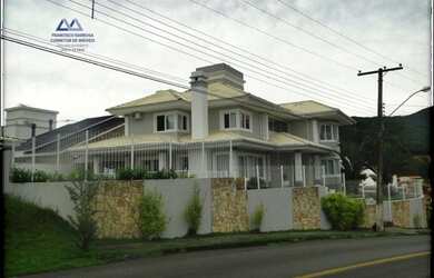 Imagem: A casa possui 4 Dormitórios, 4 Banheiros, 5 Vagas na garagem