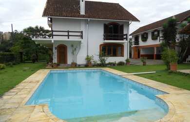 Imagem: A casa possui 4 Dormitórios, 2 Banheiros, 4 Vagas na garagem