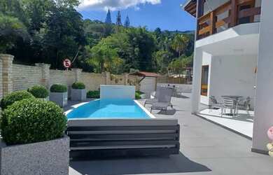 Imagem: A casa possui 4 Dormitórios, 5 Banheiros, 4 Vagas na garagem