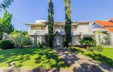 Imagem: A casa possui 4 Dormitórios, 5 Banheiros, 4 Vagas na garagem