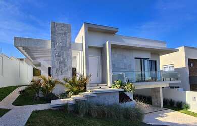 Imagem: A casa possui 3 Dormitórios, 5 Banheiros, 4 Vagas na garagem