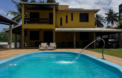 Imagem: A casa possui 5 Dormitórios, Acomodam 12 pessoas e 5 Vagas