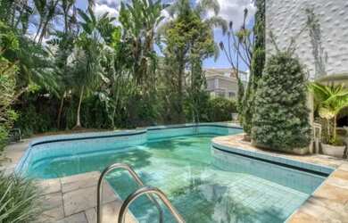 Imagem: A casa possui 4 Dormitórios, 4 Banheiros, 5 Vagas na garagem