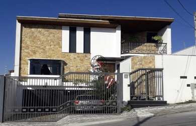 Imagem: A casa possui 3 Dormitórios, 5 Banheiros, 4 Vagas na garagem