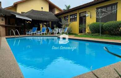 Imagem: A casa possui 3 Dormitórios, 5 Banheiros, 4 Vagas na garagem