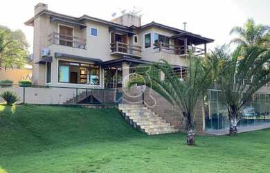 Imagem: A casa possui 4 Dormitórios, 5 Banheiros, 4 Vagas na garagem