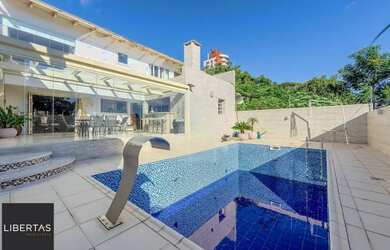 Imagem: A casa possui 5 Dormitórios, 4 Banheiros, 4 Vagas na garagem