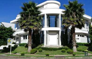 Imagem: A casa possui 4 Dormitórios, 5 Banheiros, 4 Vagas na garagem