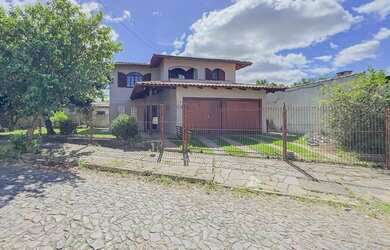 Imagem: A casae possui 5 Dormitórios, 1 Suíte, 4 Banheiros, 2 Vagas